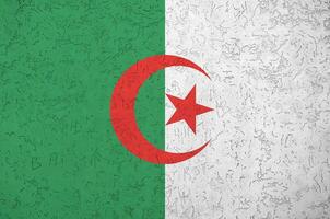 bandeira da argélia retratada em cores brilhantes de tinta na parede de reboco em relevo antigo. banner texturizado em fundo áspero foto