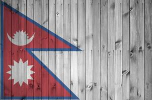 Nepal bandeira retratado dentro brilhante pintura cores em velho de madeira muro. texturizado bandeira em rude fundo foto