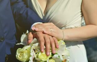 o casal recém-casado está segurando um lindo buquê de casamento. fotografia de casamento clássica, simbolizando unidade, amor e a criação de uma nova família foto