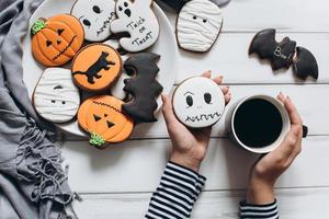 mulher se preparando para o halloween, bebendo café com pão de gengibre foto