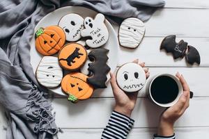 mulher se preparando para o halloween, bebendo café com pão de gengibre foto