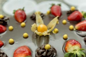 close up de bolo de chocolate com physalis e morango. foto