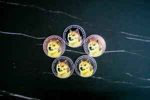 5 doge moedas doge arranjado dentro uma círculo em uma Preto mármore fundo. foto