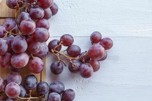 frutas frescas de uva vermelha em fundo de madeira foto
