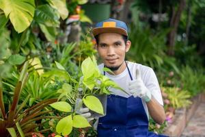 homem asiático feliz vende jardim de plantas na loja