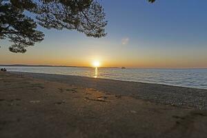 pôr do sol em a de praia dentro a croata costeiro Cidade do fazana foto