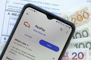 ternopil, Ucrânia - agosto 3, 2023 pessoas pagam inscrição em tela em moderno Smartphone. oficial aplicativo do famoso polonês banco foto