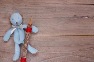 modelo de mesa de prancha boneca de urso azul segurando um lápis de madeira foto