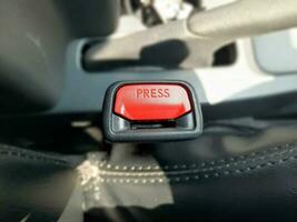 botão para liberação a assento cinto em a assento do uma carro. vermelho botão. foto