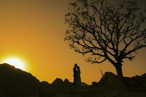 casal em a de praia às pôr do sol silhuetas-românticas verão foto