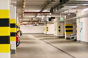 típica subterrâneo carro estacionamento garagem dentro uma moderno apartamento casa. interior pilares pintado amarelo. foto
