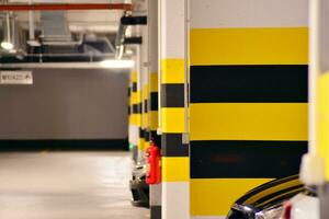 típica subterrâneo carro estacionamento garagem dentro uma moderno apartamento casa. interior pilares pintado amarelo. foto