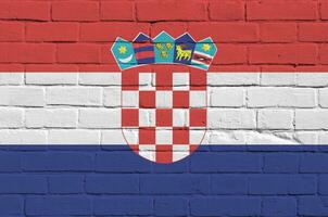 Croácia bandeira retratado dentro pintura cores em velho tijolo muro. texturizado bandeira em grande tijolo parede alvenaria fundo foto