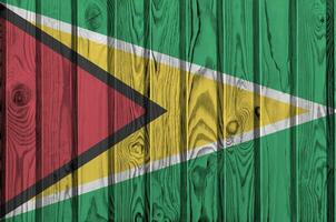 Guiana bandeira retratado dentro brilhante pintura cores em velho de madeira muro. texturizado bandeira em rude fundo foto
