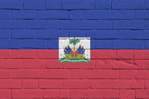 Haiti bandeira retratado dentro pintura cores em velho tijolo muro. texturizado bandeira em grande tijolo parede alvenaria fundo foto