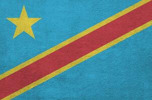 bandeira da república democrática do congo retratada em cores de tinta brilhante na parede de reboco em relevo antigo. banner texturizado em fundo áspero foto