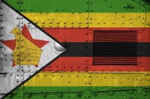 Zimbábue bandeira retratado em lado parte do militares blindado tanque fechar-se. exército forças conceptual fundo foto