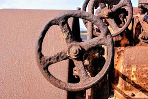 uma oxidado velho máquina com uma roda e uma direção roda foto