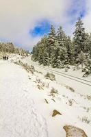 caminhantes pessoas em nevou na paisagem brocken montanhas harz alemanha. foto