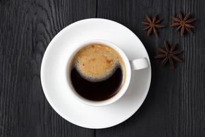 café quente com espuma em uma xícara branca com erva-doce foto