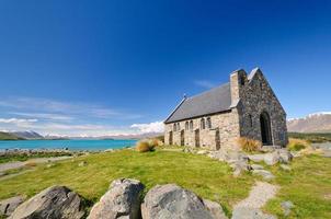 igreja rústica à beira de um lago alpino foto