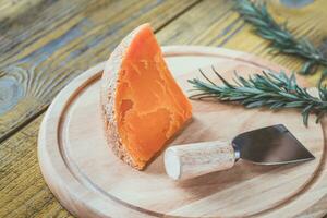 queijo mimolette na tábua de madeira foto