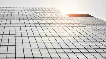 vidro moderno construção com azul céu fundo. Visão e arquitetura detalhes. urbano abstrato - janelas do vidro escritório construção dentro luz solar dia. Preto e branco. foto