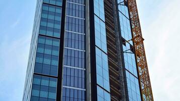 Visão do uma arranha-céu debaixo construção. moderno arquitetura fundo. construção uma arranha-céus prédio, a conceito do real Estado construção. foto