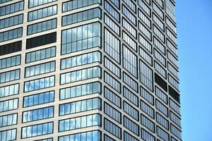 inferior Visão do moderno arranha-céus dentro o negócio distrito contra azul céu. olhando acima às o negócio edifícios dentro centro da cidade. foto