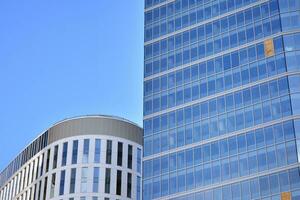 vidro construção com transparente fachada do a construção e azul céu. estrutural vidro parede refletindo azul céu. abstrato moderno arquitetura fragmento. contemporâneo arquitetônico fundo. foto