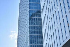 vidro construção com transparente fachada do a construção e azul céu. estrutural vidro parede refletindo azul céu. abstrato moderno arquitetura fragmento. contemporâneo arquitetônico fundo. foto