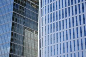 vidro construção com transparente fachada do a construção e azul céu. estrutural vidro parede refletindo azul céu. abstrato moderno arquitetura fragmento. contemporâneo arquitetônico fundo. foto