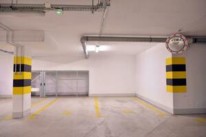 saída a partir de a subterrâneo garagem com branco portão. interior pilares pintado amarelo. foto