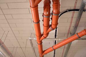 sanitário sistema tubos e elétrico cabos instalado debaixo plano laje reforçado concreto estrutura dentro prédio. foto
