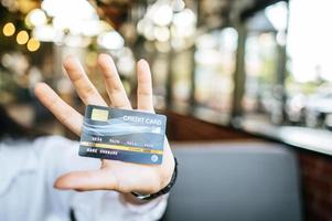 mulher segurando cartão de crédito em restaurante foto