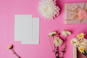 caixa de presente rosa, flor e cartão em branco sobre fundo rosa foto