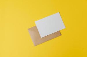 um cartão em branco com envelope é colocado em fundo amarelo