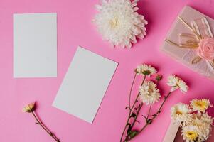 caixa de presente rosa, flor e cartão em branco sobre fundo rosa foto