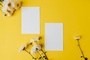 dois cartões em branco com flores são colocados em fundo amarelo foto