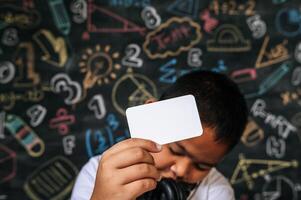 criança agindo com cartão em branco na sala de aula foto