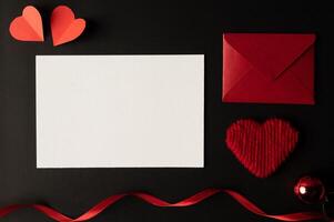 papel branco e papel de coração vermelho colados em um fundo preto. foto