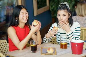 alegre ásia mulheres comendo delicioso Comida durante almoço juntos foto