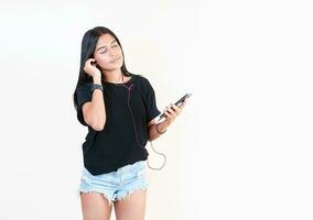 atraente menina desfrutando música com telefone isolado. feliz latim gir ouvindo para música com célula telefone isolado. retrato do lindo menina ouvindo para música com Smartphone isolado foto