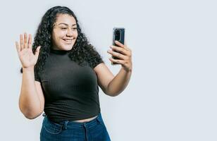 sorridente lindo latim mulher fazer uma vídeo ligar isolado. feliz nicaraguense mulher fazer uma vídeo ligar em isolado fundo foto