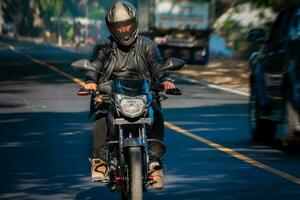 masculino motociclista dirigindo às Alto Rapidez em a rua. motocicleta motorista às cheio Rapidez em a autoestrada. foto