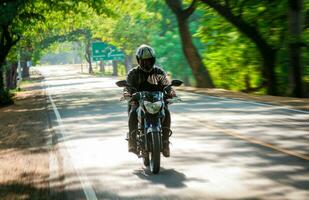 masculino motociclista dirigindo às Alto Rapidez em a rua. motocicleta motorista às cheio Rapidez em a autoestrada. foto