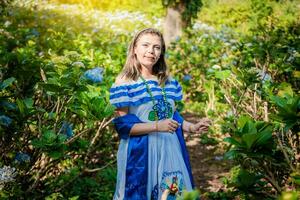 sorridente mulher dentro nacional folk traje dentro uma campo cercado de flores nicaraguense nacional folk fantasia, jovem nicaraguense mulher dentro tradicional folk traje dentro uma campo do mil flores foto