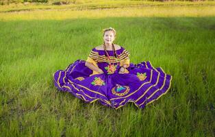 nicaraguense mulher dentro tradicional folk vestir sentado em a Relva dentro a campo, retrato do nicaraguense mulher vestindo nacional folk vestir foto