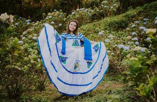 menina dentro nicaraguense nacional folk fantasia. jovem nicaraguense mulher dentro tradicional folk traje dentro uma campo do milflores, sorridente menina dentro nacional folk traje dentro uma campo cercado de flores foto