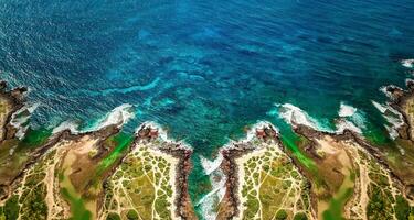 aéreo Visão do oceano ondas e fantástico rochoso litoral, aéreo Visão do uma litoral ao longo ótimo oceano estrada, aéreo Visão do ondas batendo pedras em de praia com turquesa água foto